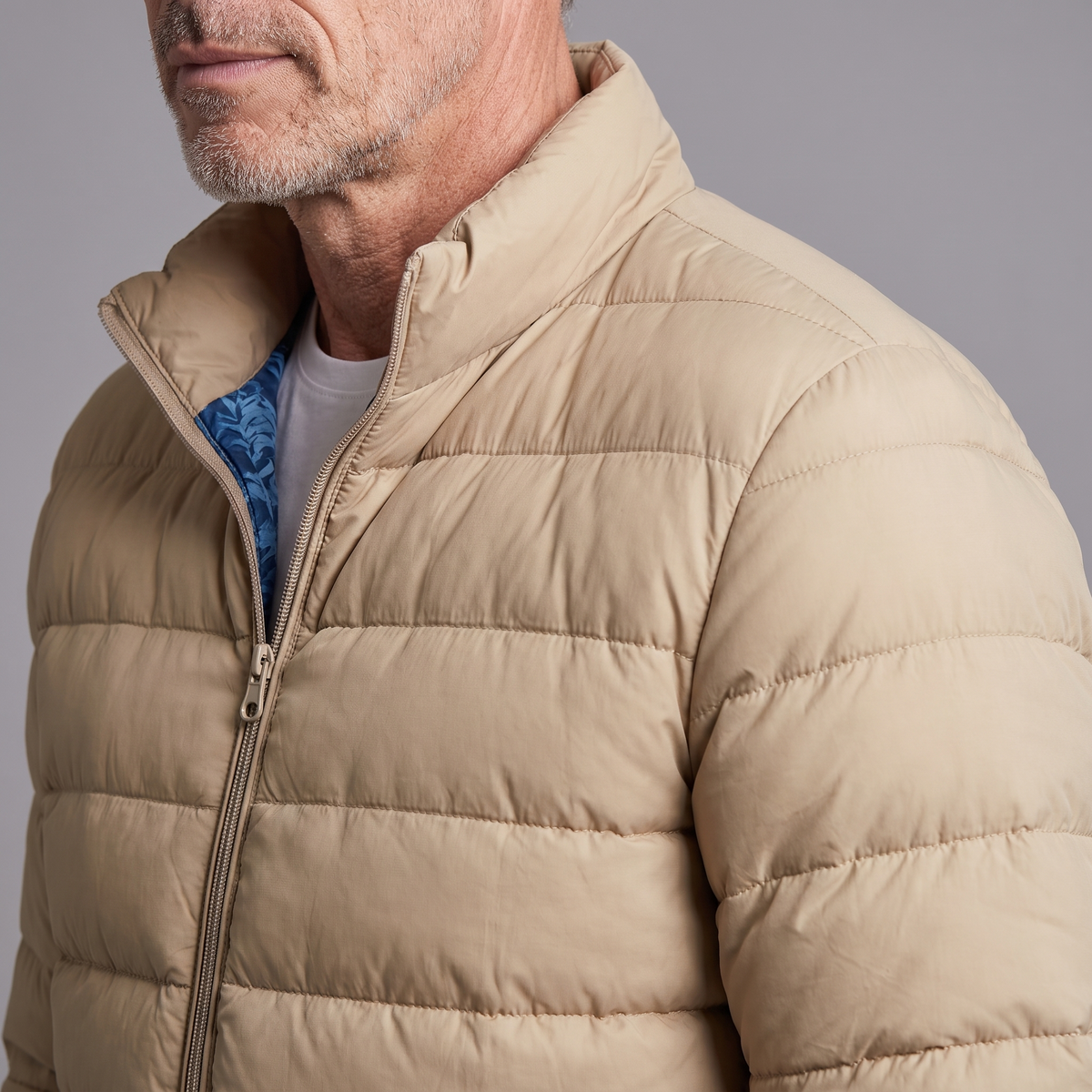 Men's lightweight puffer jacket, close-up of stand collar and quilting
