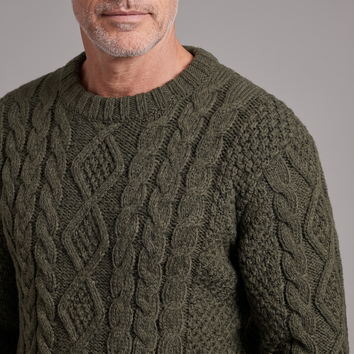 Men's Aran cable knit sweater, close-up of cable knit texture and ribbed crew neck