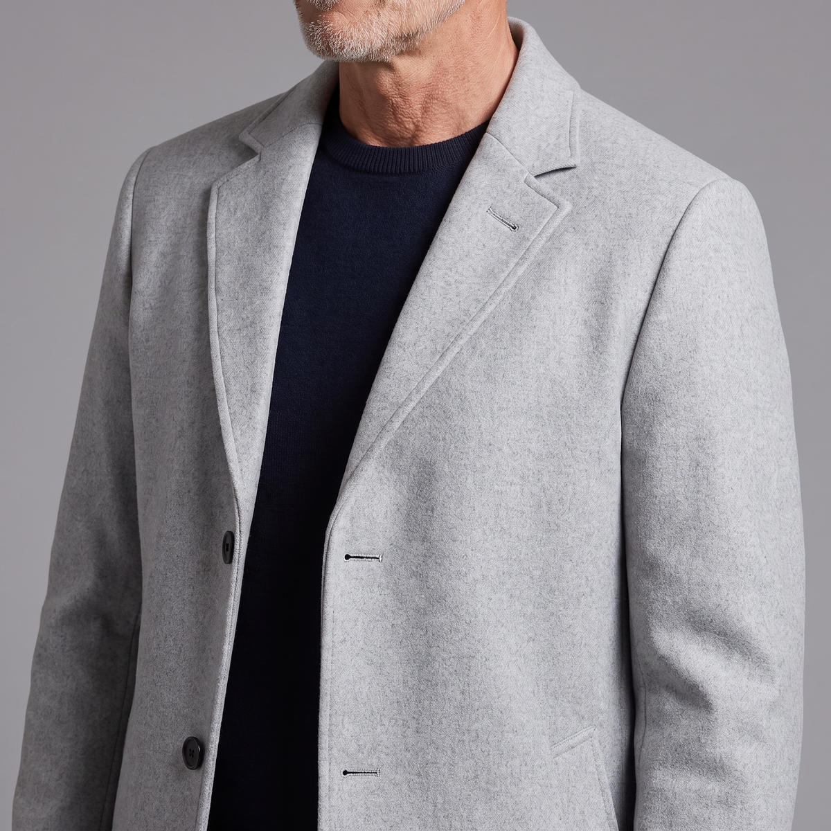 Men's wool-blend overcoat, close-up of notched lapel, buttons and fabric texture