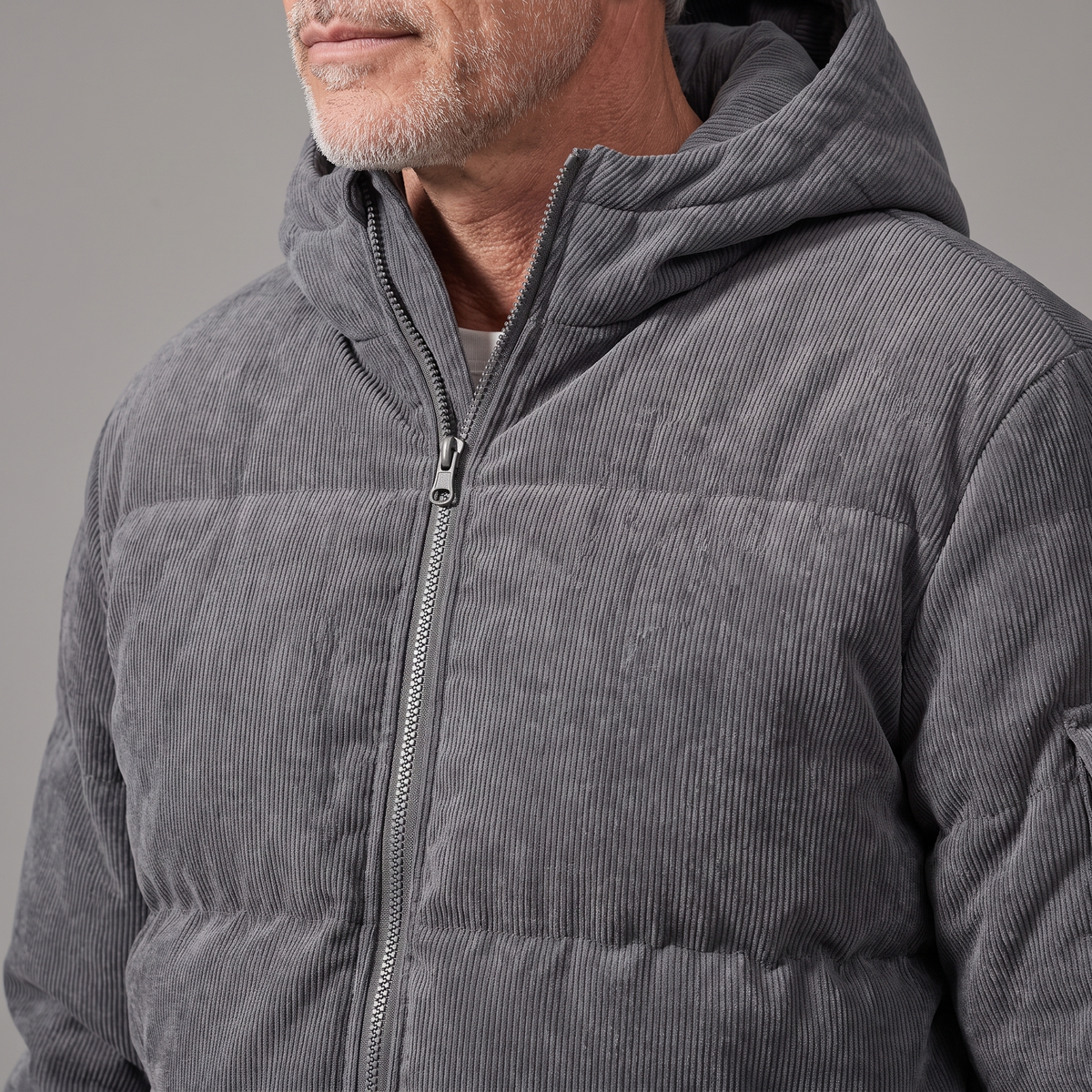 Men's corduroy hooded puffer jacket, close-up of corduroy texture and front zip