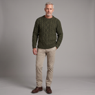 Men's Aran cable knit sweater in army green, full-body standing shot