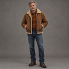 Men's sherpa-lined suede bomber jacket, full-body standing shot, gray studio background