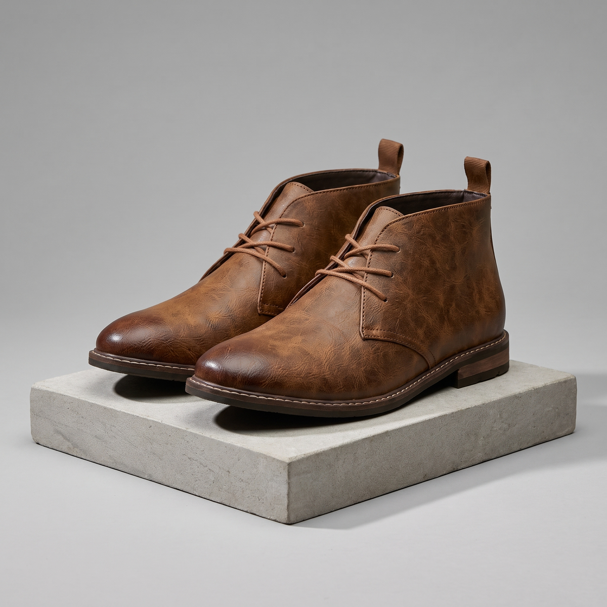 Men's full-grain leather lace-up chukka boots in brown, 3/4 angle gray pedestal shot
